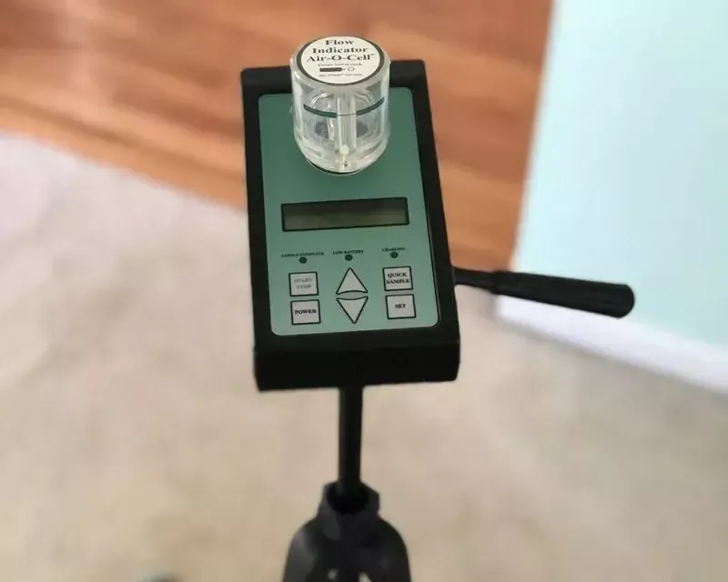 Air sampling pump with a spore trap cassette set up in a living room